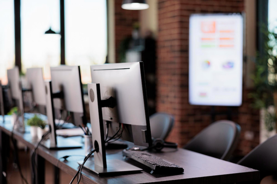Modern office workspace with computer stations, representing telecommunications industry and digital connectivity solutions.