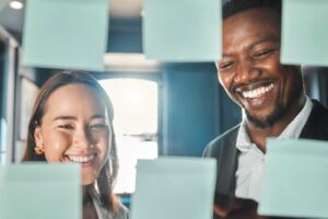 Two professionals collaborating with workflow notes, showcasing how Nucleus operations management software streamlines processes and boosts efficiency.