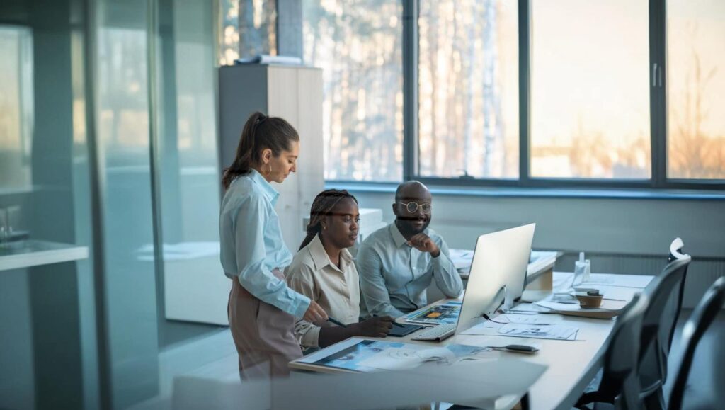 Sales team collaborating on computer using Nucleus CRM to manage leads and customer relationships.