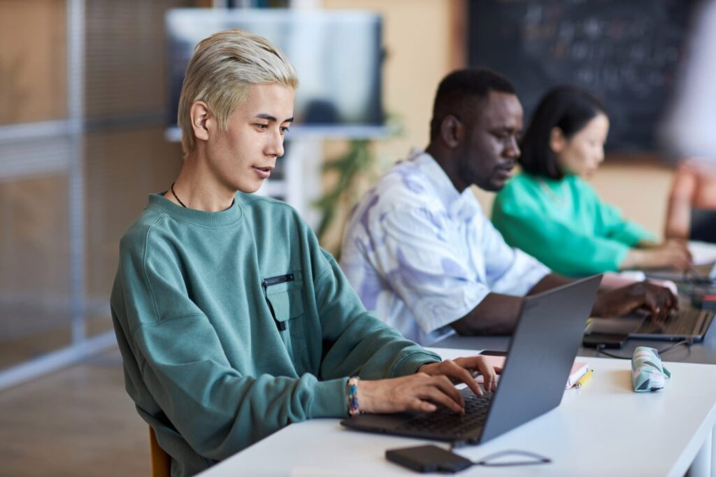 Team working on laptops in an office, using Nucleus Accounting to connect service and finance operations.