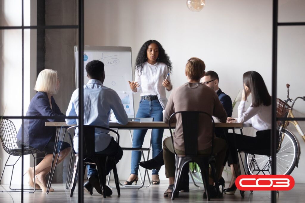 Team in a business meeting discussing strategies with a whiteboard, leveraging Business Automation Tools to improve workflows and efficiency