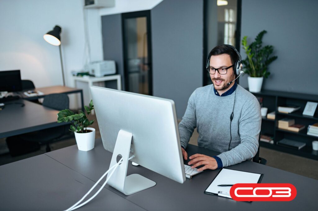 Professional using computer with headset – best field service management software UK for efficient customer support and operations.