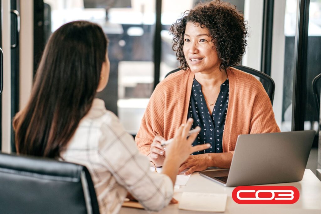 Two professionals discussing project progress using job tracking software to improve workflow and team collaboration.