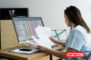 Professional reviewing documents and data on screen using a contract management system for secure billing and compliance tracking.
