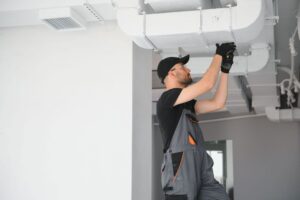 Technician repairing an HVAC system using HVAC field service software insights to improve efficiency and maintenance accuracy.