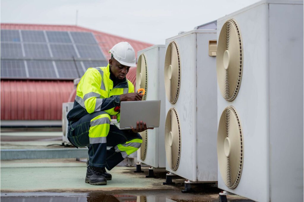 HVAC technician servicing outdoor units, supported by HVAC field service software for efficient maintenance.