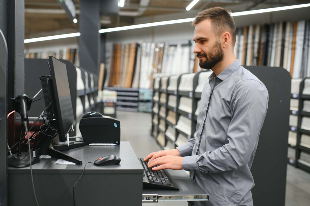 Office equipment technician using an inventory management system to track parts and service stock